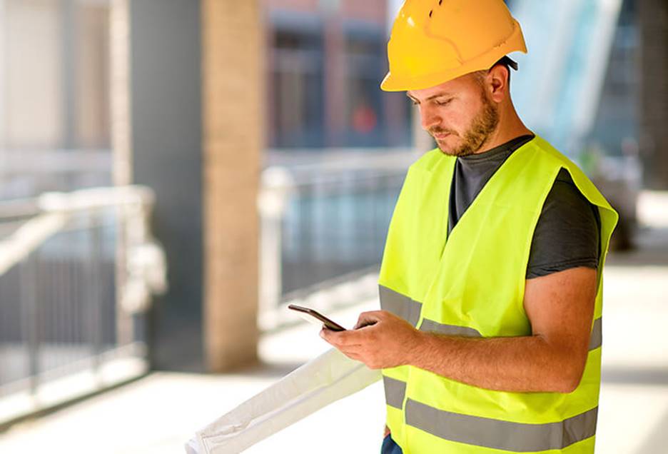 Engineer on construction site checking his phone